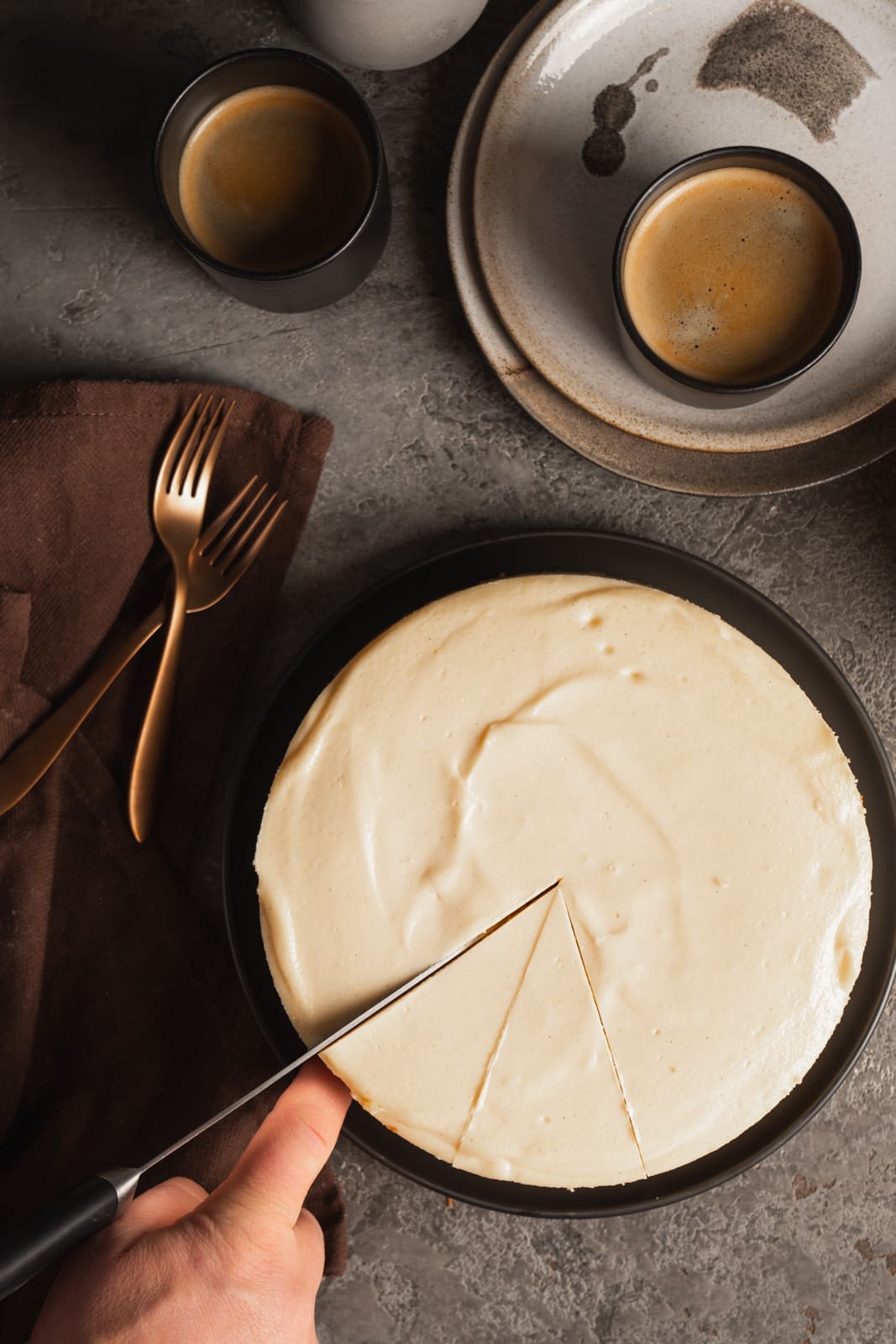Ganzer New York Cheesecake von oben, wird gerade angeschnitten