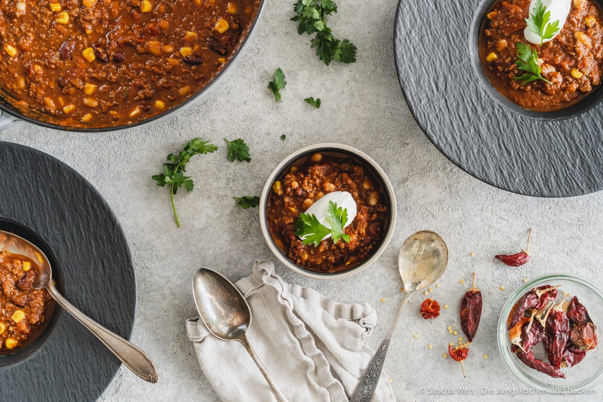 Chili con carne 1 Chili Con Carne 1 | Torsten und ich haben Anfang des Monats unsere Geburtstage nachgefeiert. Da wir aber nur ein paar Tage vorher aus dem Urlaub zurückgekommen sind, war nicht wirklich viel Zeit für riesige Vorbereitungen. Daher haben wir auf einen Partyfood-Klassiker schlechthin zurückgegriffen - ein leckeres Chili con carne! Denn ein geniales Chili lässt sich in riesigen Mengen und mit super wenig Vorbereitung zubereiten - eigentlich macht es sich fast von alleine. Trotzdem hat wahrscheinlich jeder ein etwas anderes Rezept für sein Chili con carne zur Hand. In unsere Version kommen 1-2, für unsere Freunde, unwahrscheinlichen Zutaten, aber genau die machen es aus.