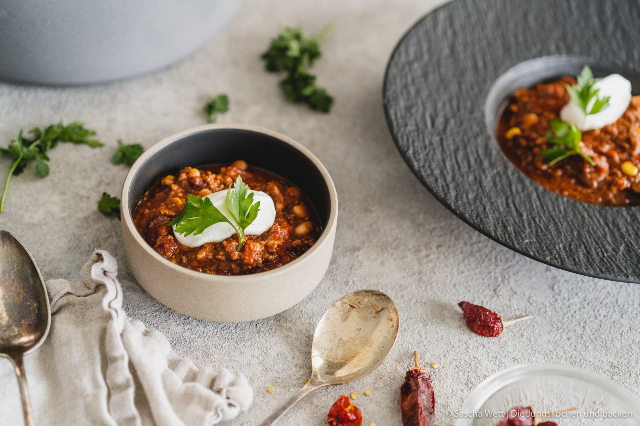 Chili con carne 2 Chili Con Carne 3 | Torsten und ich haben Anfang des Monats unsere Geburtstage nachgefeiert. Da wir aber nur ein paar Tage vorher aus dem Urlaub zurückgekommen sind, war nicht wirklich viel Zeit für riesige Vorbereitungen. Daher haben wir auf einen Partyfood-Klassiker schlechthin zurückgegriffen - ein leckeres Chili con carne! Denn ein geniales Chili lässt sich in riesigen Mengen und mit super wenig Vorbereitung zubereiten - eigentlich macht es sich fast von alleine. Trotzdem hat wahrscheinlich jeder ein etwas anderes Rezept für sein Chili con carne zur Hand. In unsere Version kommen 1-2, für unsere Freunde, unwahrscheinlichen Zutaten, aber genau die machen es aus.