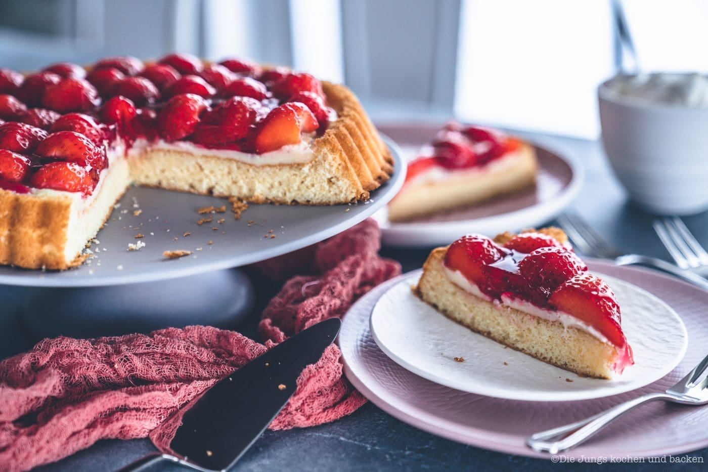 Erdbeerkuchen mit Pudding 8 | Heute kommen wir wieder mit einem schnellen Klassiker von zu Hause. Eine ganz klassischee Erdbeerkuchen mit Pudding. Ein simpler Obstboden mit etwas Puddingcreme und frischen Erdbeeren drauf. Das ist auch wieder so etwas, dass Oma Lore früher immer schnell mal so aus dem Nichts gezaubert hat. Immer dann, wenn entweder unangekündigter Besuch vor der Türe stand oder sie die Erdbeeren aus dem Garten verarbeiten wollte, damit sie sich nicht zu lange im Kühlschrank stapelten.