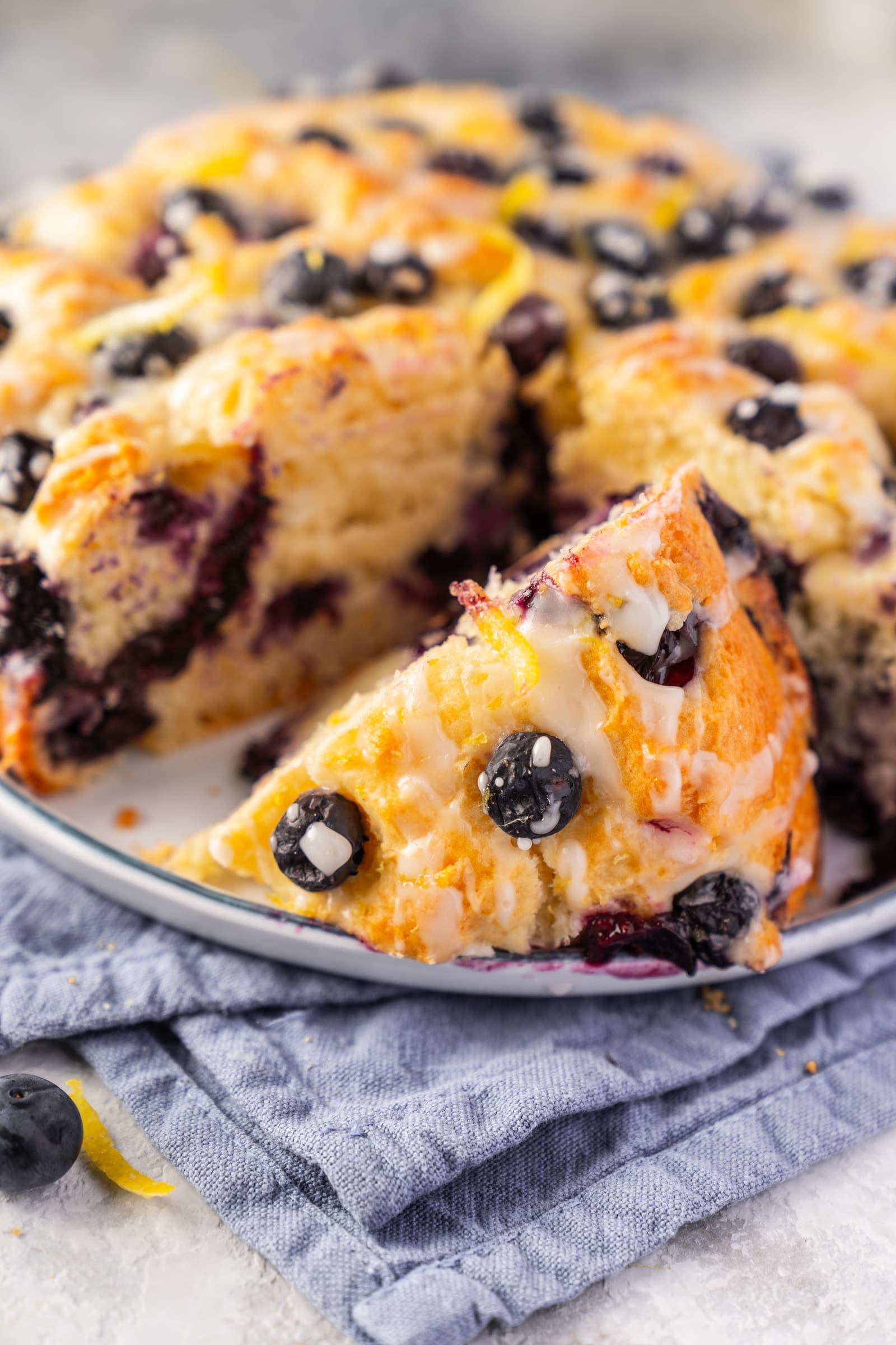 Schneller Blaubeerkuchen mit herausgeschnittenem Stück auf einem Teller