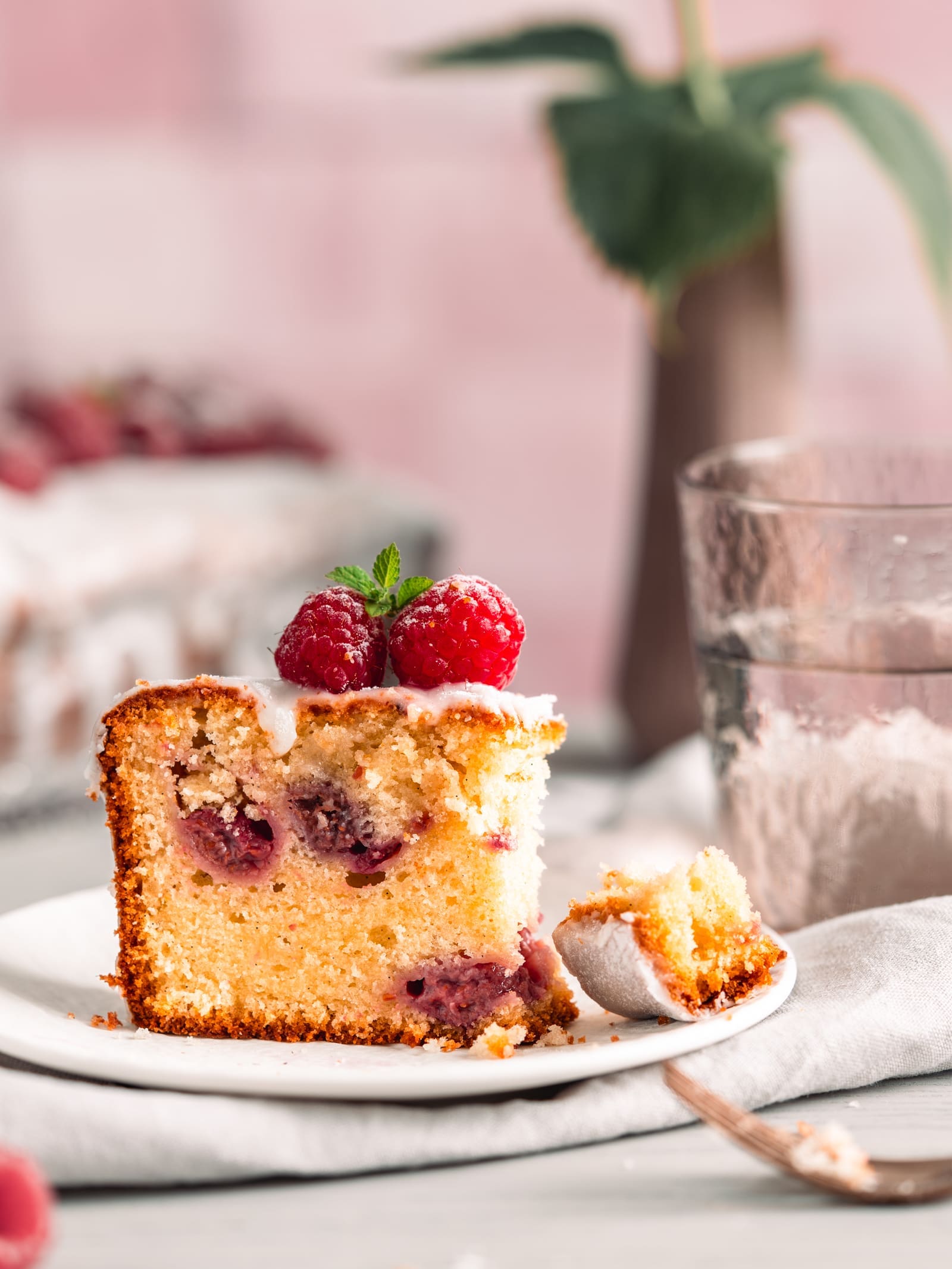 Angeschnittenes Stück Joghurt-Himbeerkuchen aus der Kastenform mit Gabel